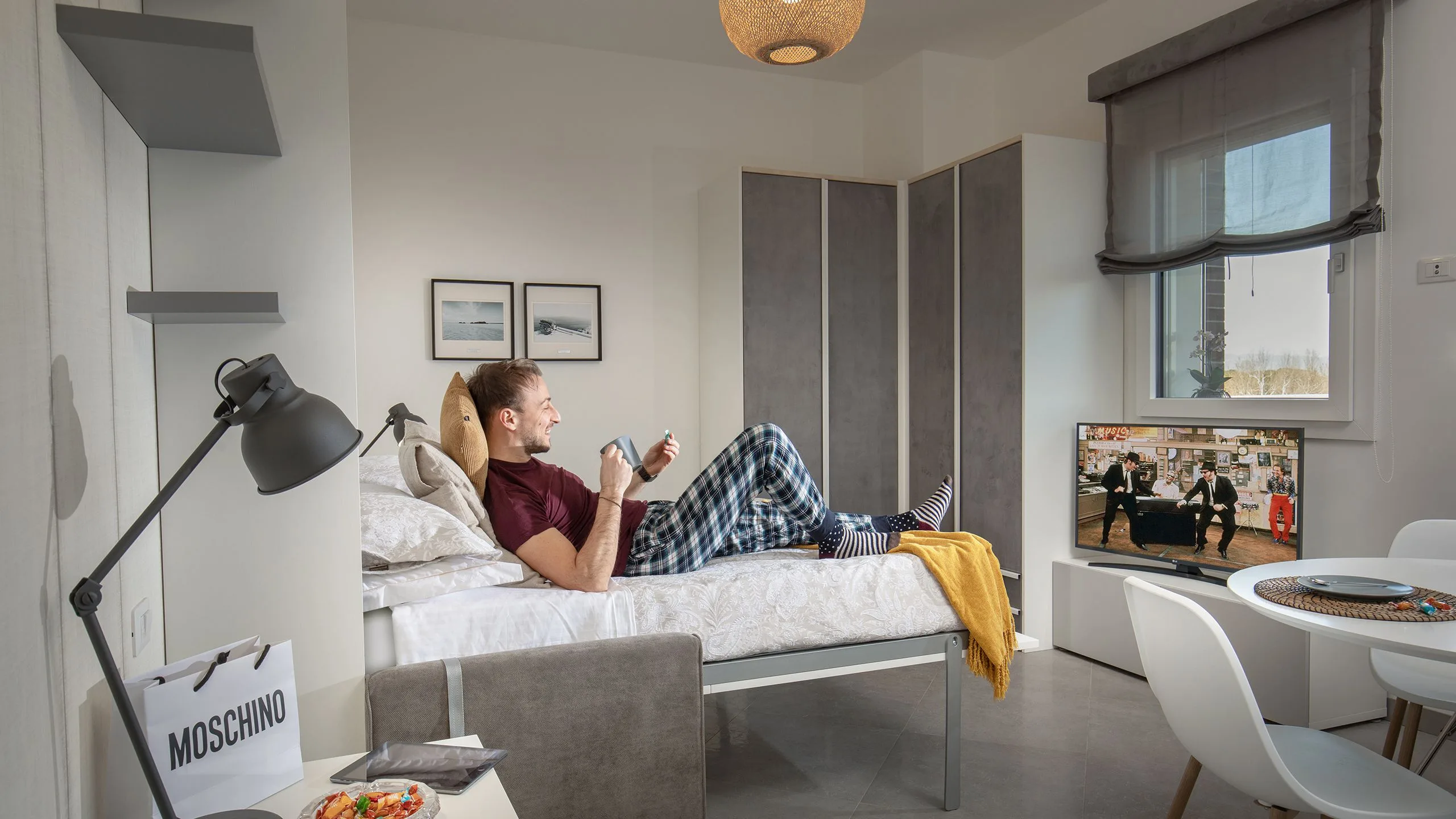 Monolocale con letto, televisore e armadio angolare